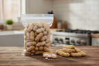 Fresh raw peanuts in clear bag on rustic kitchen counter